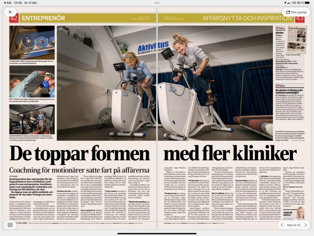 Två personer som använder motionscyklar inomhus, med i en svensk tidningsartikel med rubriken som diskuterar coaching och clinics.